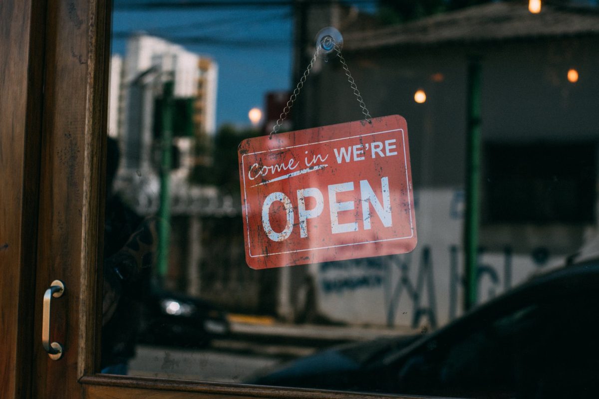 open signage hanging on glass door of vicinity